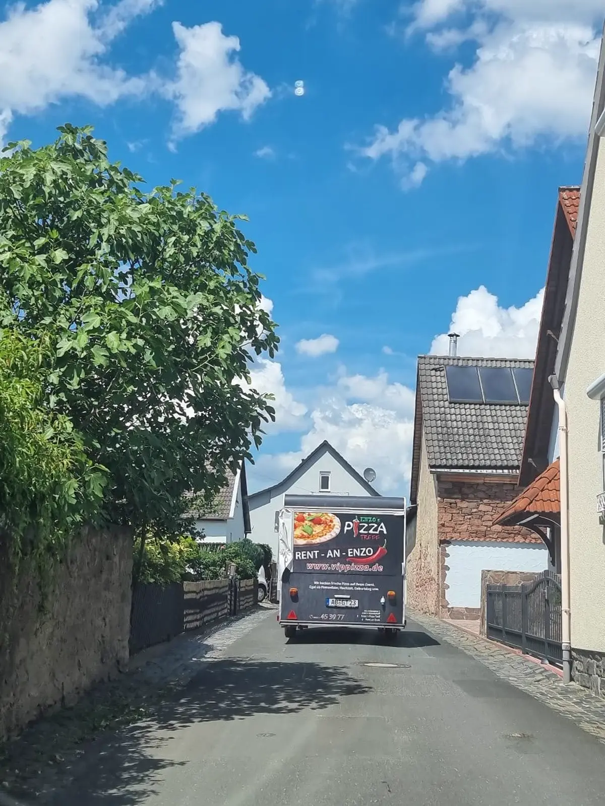 Gebrandeter Pizza-Anhänger in einer schmalen Gasse