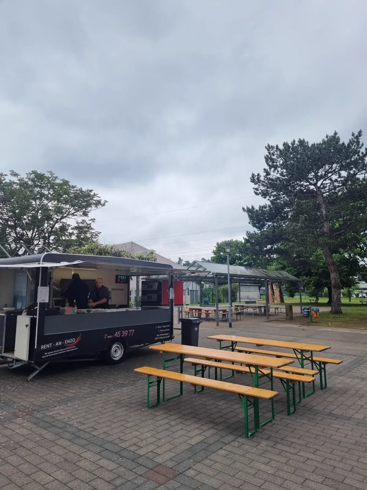 Pizza-Anhänger mit Bänken auf einem Eventgelände