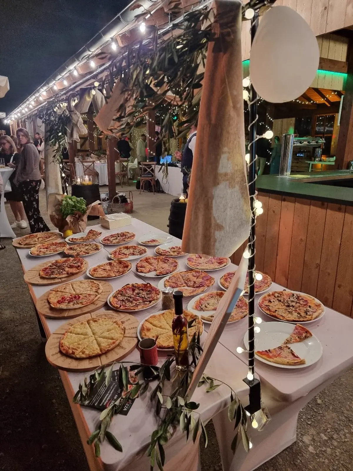 Langes Pizza-Buffet mit vielen Sorten bei einer Abendveranstaltung