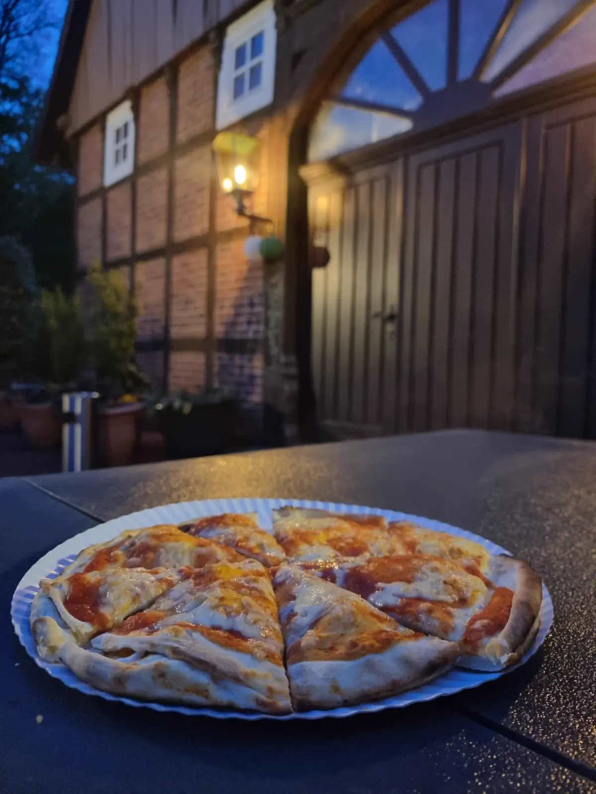 Pizza im Vordergrund vor einer beleuchteten Event-Location