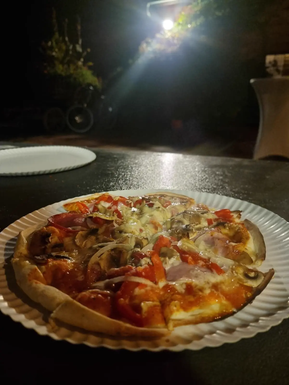 Frisch gebackene Pizza in dunkler Abendstimmung