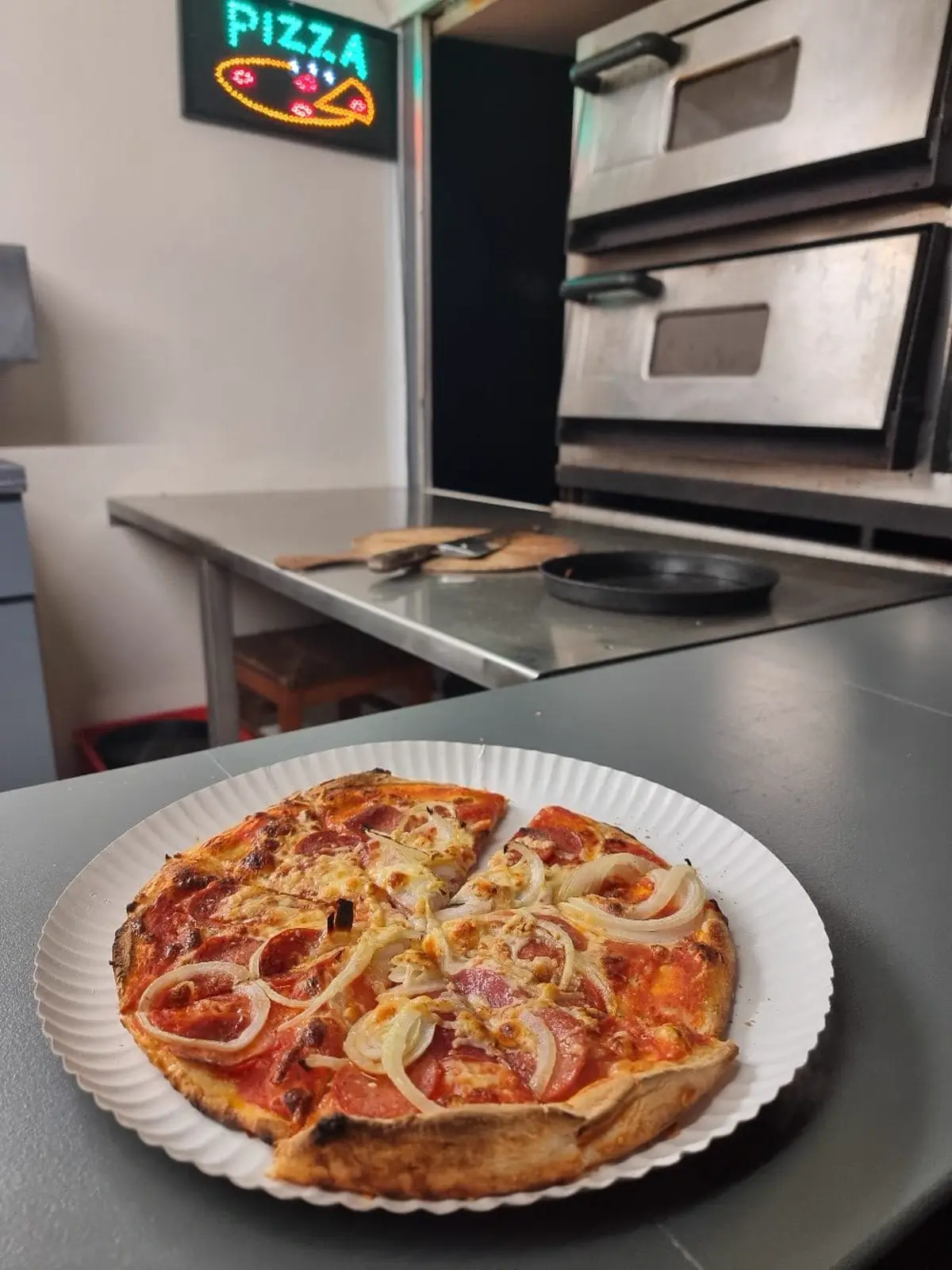 Frisch gebackene Pizza auf einem Teller vor dem Ofen